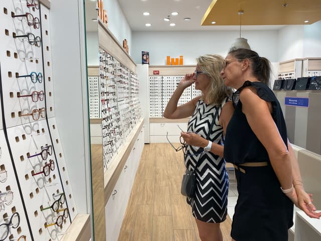 Une cliente et une opticienne regarde les choix de montures